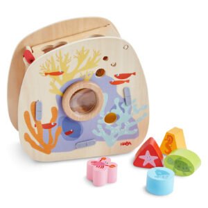 Wooden toy shape sorter with underwater theme, featuring fish and corals, with various shaped blocks in front.